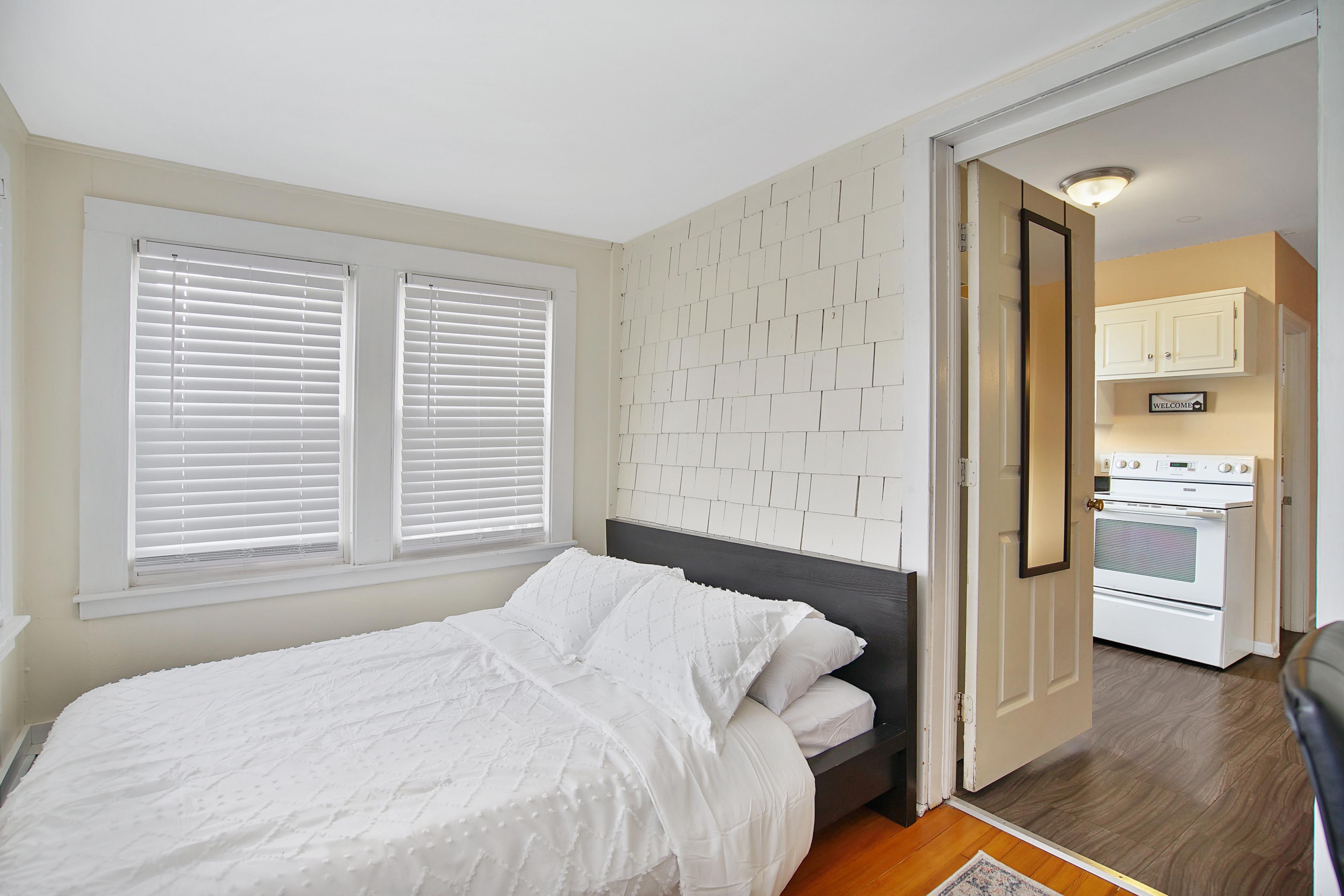 Second bedroom with queen bed, dresser, and runner rug