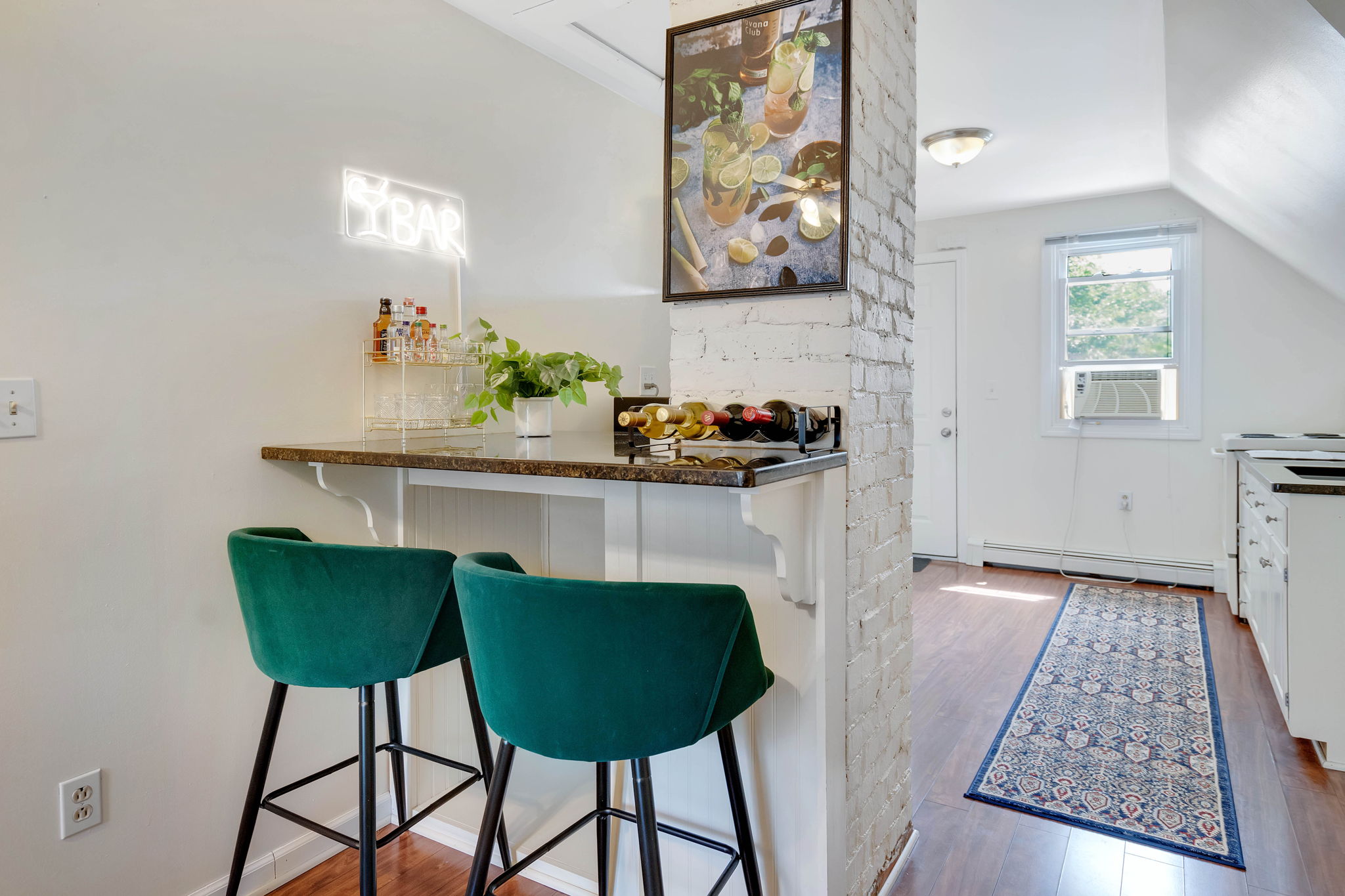 In-unit minibar with green velvet bar stools